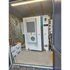 Pylontech battery storage system installed in industrial container with cooling unit, electrical panels, and safety warning l