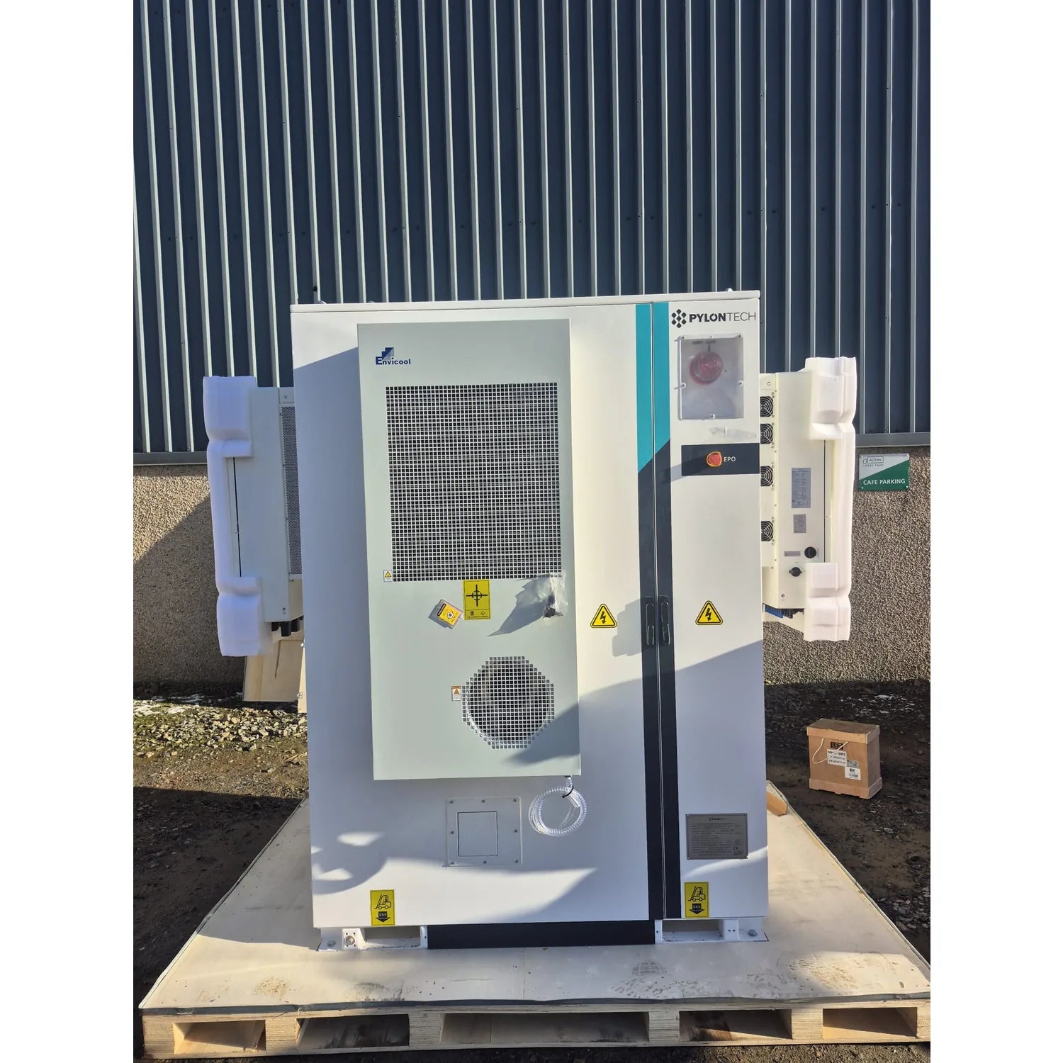 Pylontech A300 battery storage unit mounted on wooden pallet against corrugated metal backdrop, showing front panel with cool