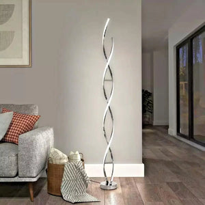 Swirl Chrome LED Floor Lamp with curved twisted design standing in modern living room next to gray sofa and woven basket.