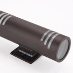 Dark brown cylindrical wall light with silver bands and black mounting bracket, shown at an angle against white background.