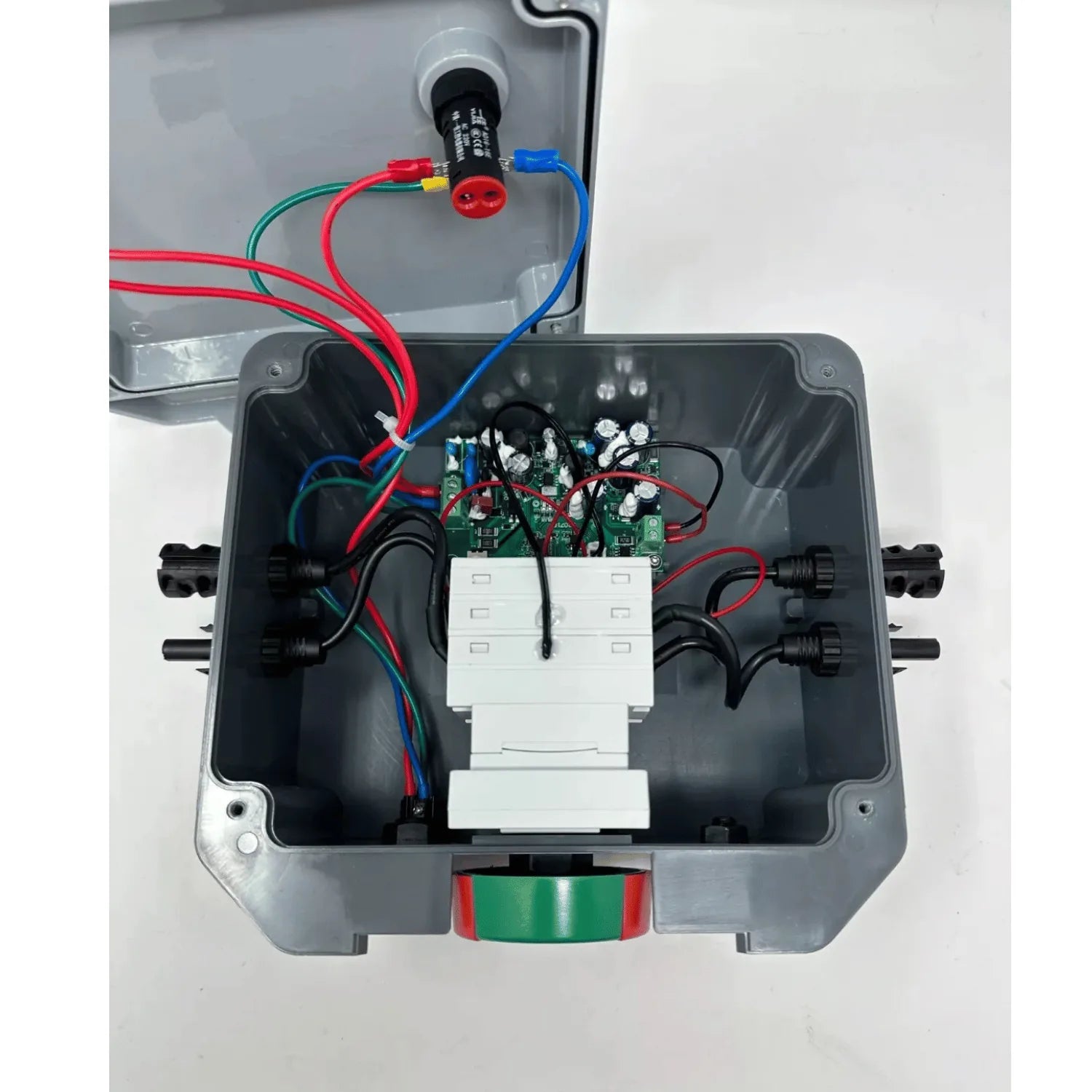Interior view of rapid shutdown switch showing circuit board, white terminal blocks, red and blue wiring, and green-red indic