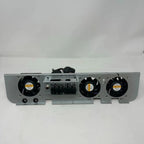 Gray metal cooling fan assembly with three black axial fans and central terminal block mounted on white background.