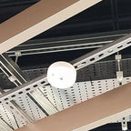 LED emergency spot light mounted on perforated ceiling rail system with white dome and mounting brackets visible.