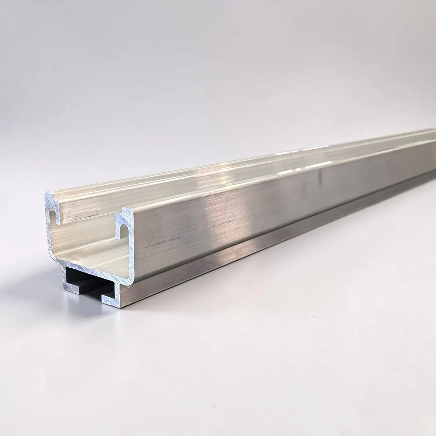Polished aluminum U-shaped mounting rail with slot detail, angled view on white background.