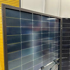 Multiple Elite bifacial solar panels mounted on display, showing front-facing dark solar cells with white gridlines and junct
