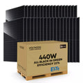Pallet of 36 black solar panels stacked behind a cardboard box labeled 440W all black in green efficiency 23% by Voltacon Pow