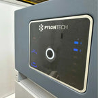 Pylontech Force H2 battery module mounted on wall with touchscreen display showing status indicators and blue LED lights.