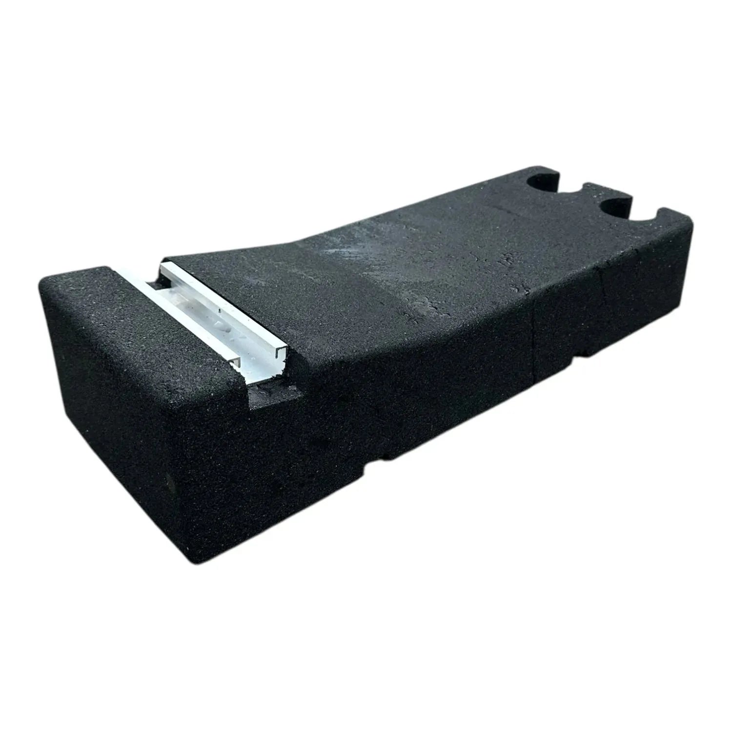 Black foam base with white metal mounting bracket for solar panel installation on flat roof.