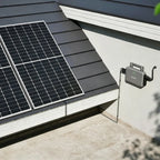 Solar panel and microinverter installation on roof with white trim and dark shingles, showing device mounted on fascia with c