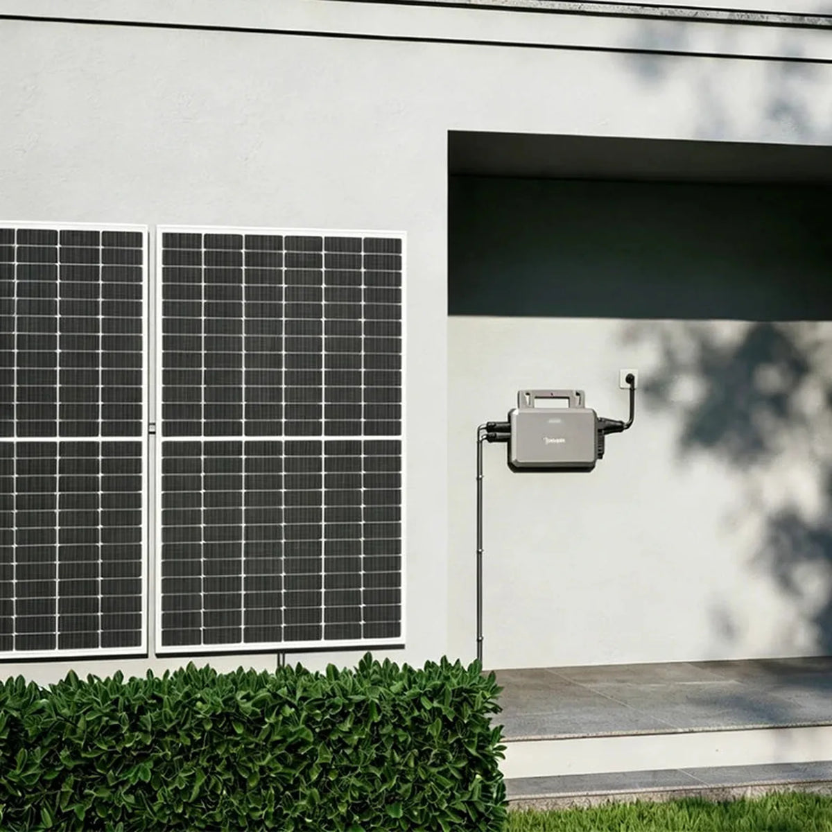 Hoymiles HF-800-WB microinverter mounted on white wall beside solar panels, with antenna and UK power cable visible.