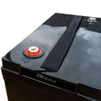 Black gel deep cycle battery with red and silver terminal cap, black textured strap, and metallic top surface against white b