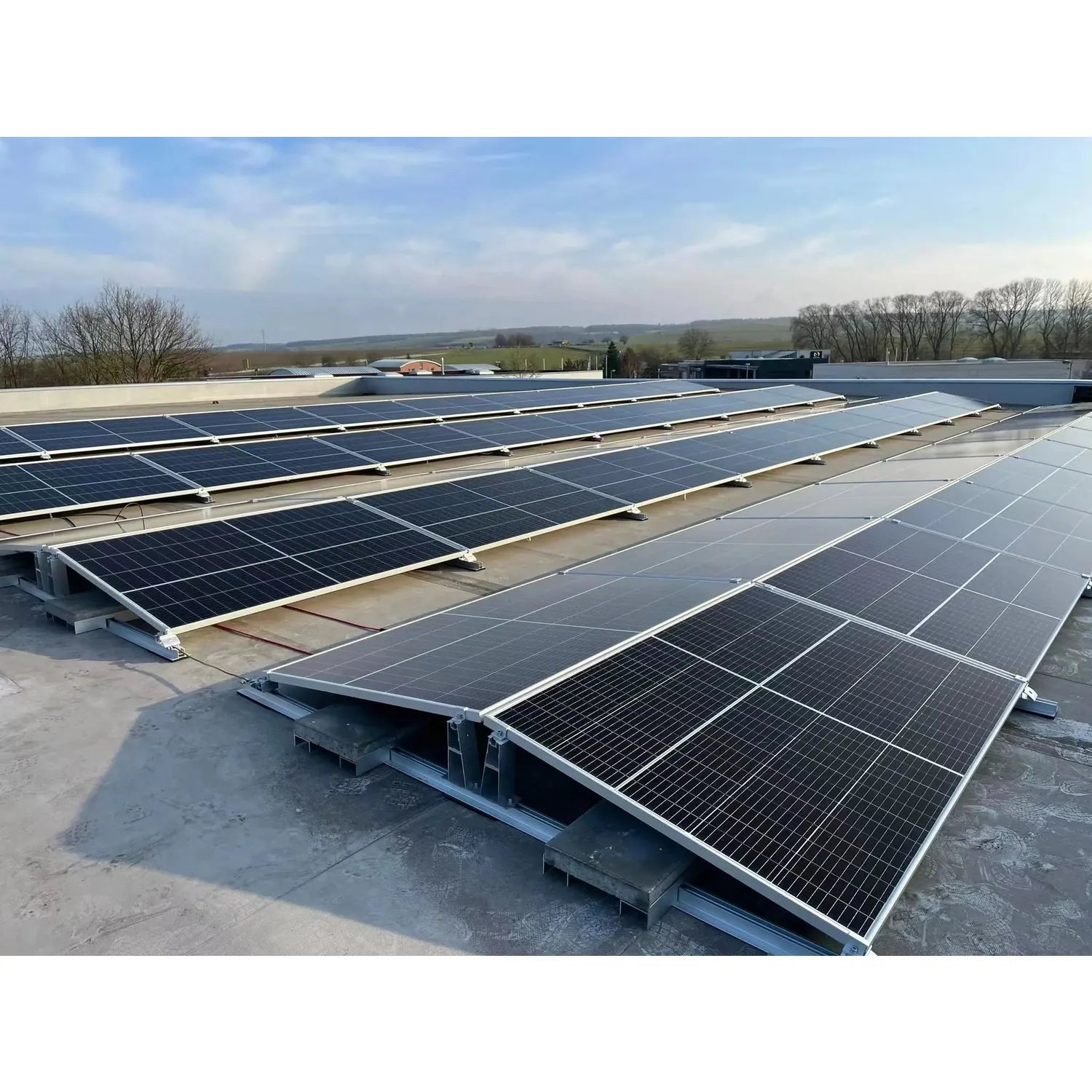 Rooftop solar panel installation showing multiple black solar panels mounted on flat concrete roof with white metal ballast f