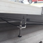 Hanger bolt with supporting plate installed under truck bed, showing threaded bolt and metal bracket attachment to vehicle un