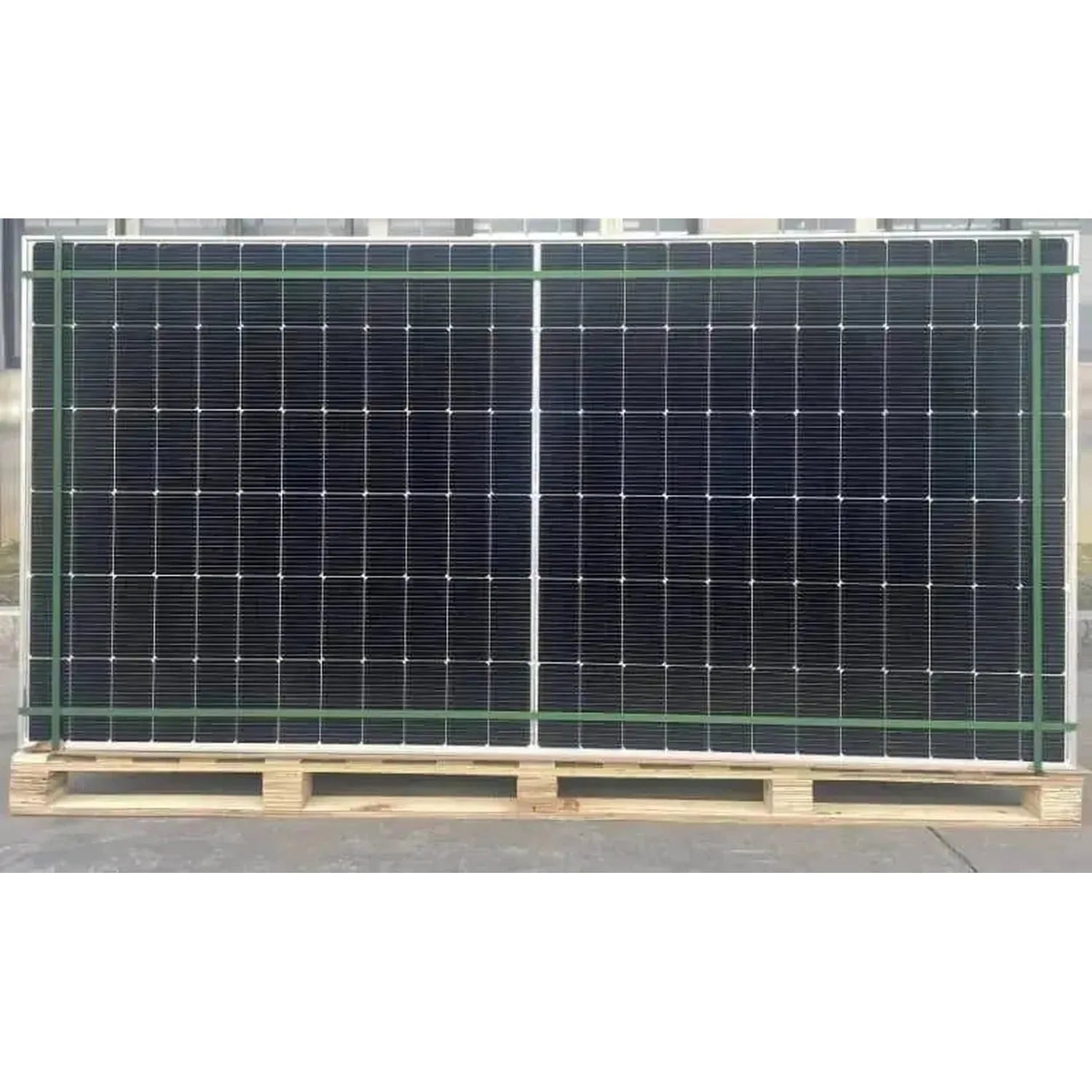 Two large black bifacial solar panels mounted on wooden pallets with green metal framing, displayed outdoors.