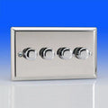 Four-gang chrome dimmer switch with circular control knobs on brushed silver faceplate against blue background.