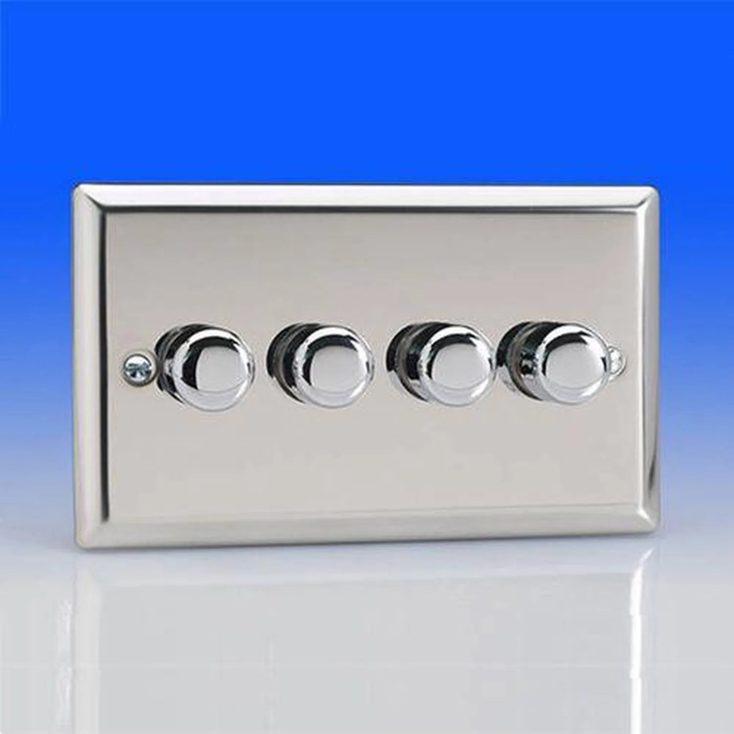 Four-gang chrome dimmer switch with circular control knobs on brushed silver faceplate against blue background.