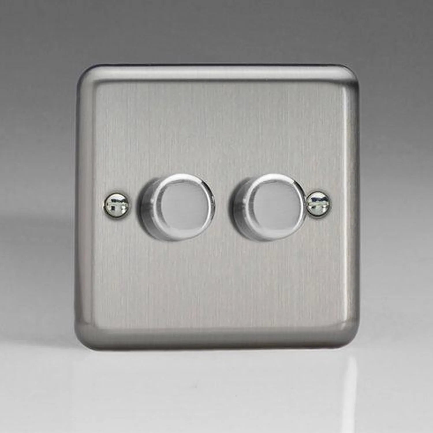 Brushed steel two-gang dimmer switch with two rotary controls and mounting screws on gray background.