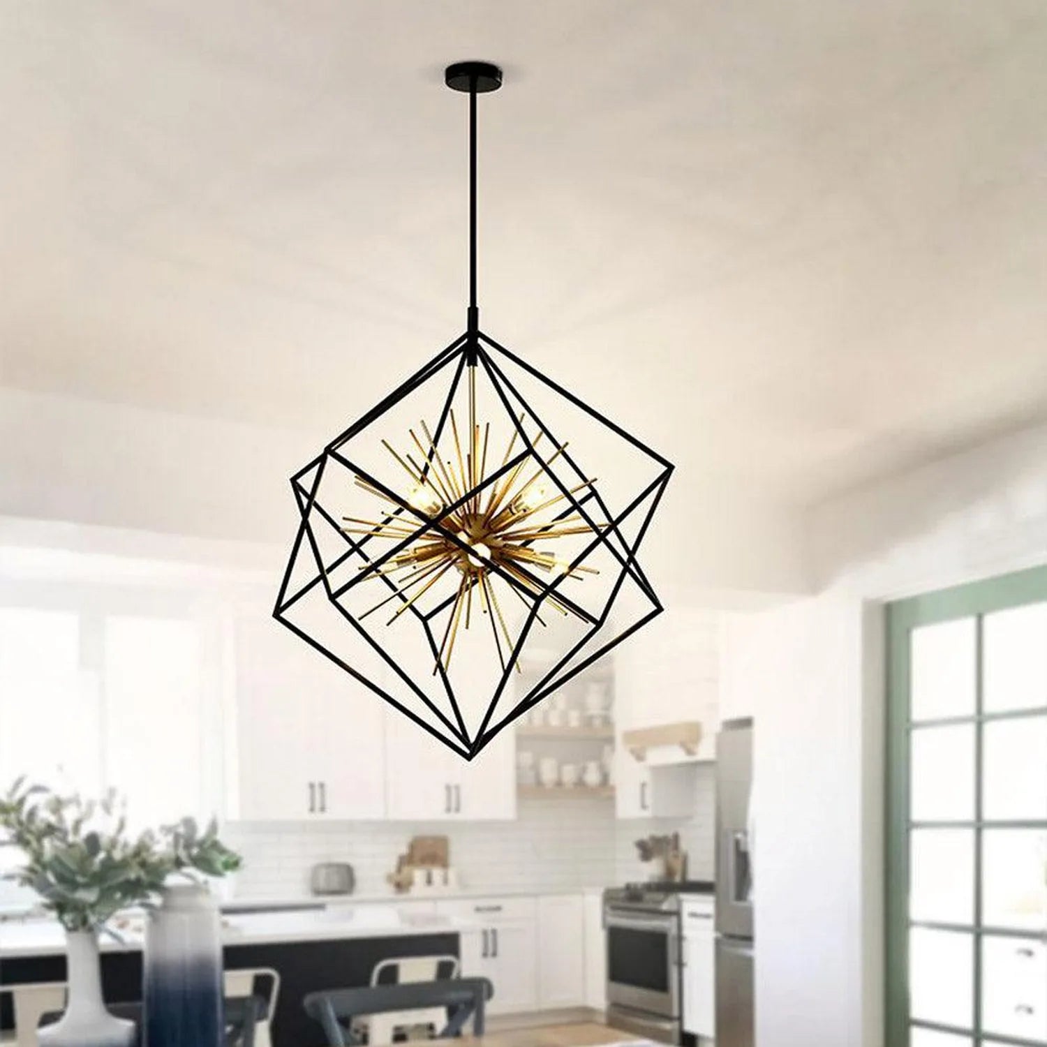 Black geometric cage pendant light with brass spiked center, installed in modern kitchen above island.