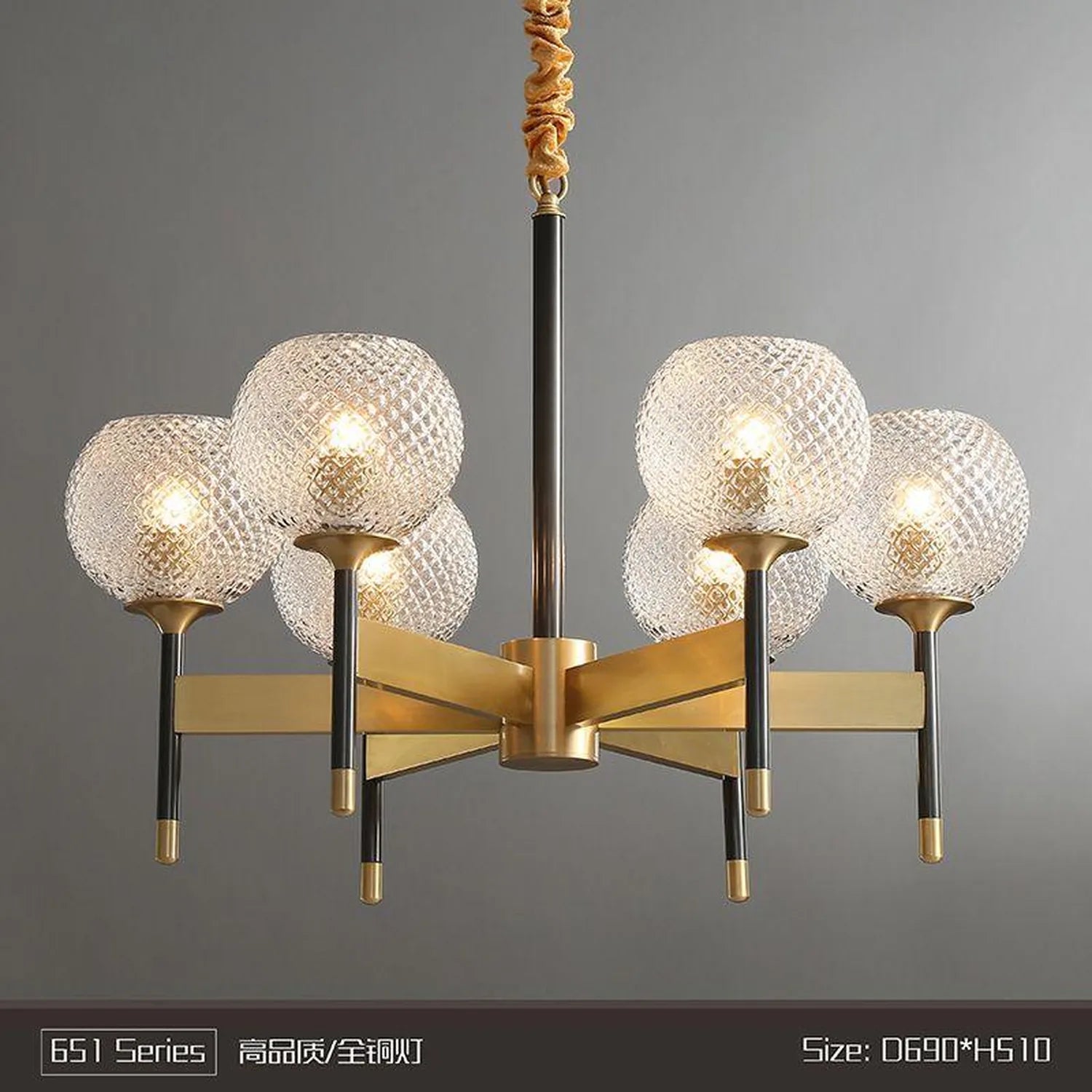 Six-way pendant chandelier with textured glass shades, brass and black metal framework, shown against neutral background with