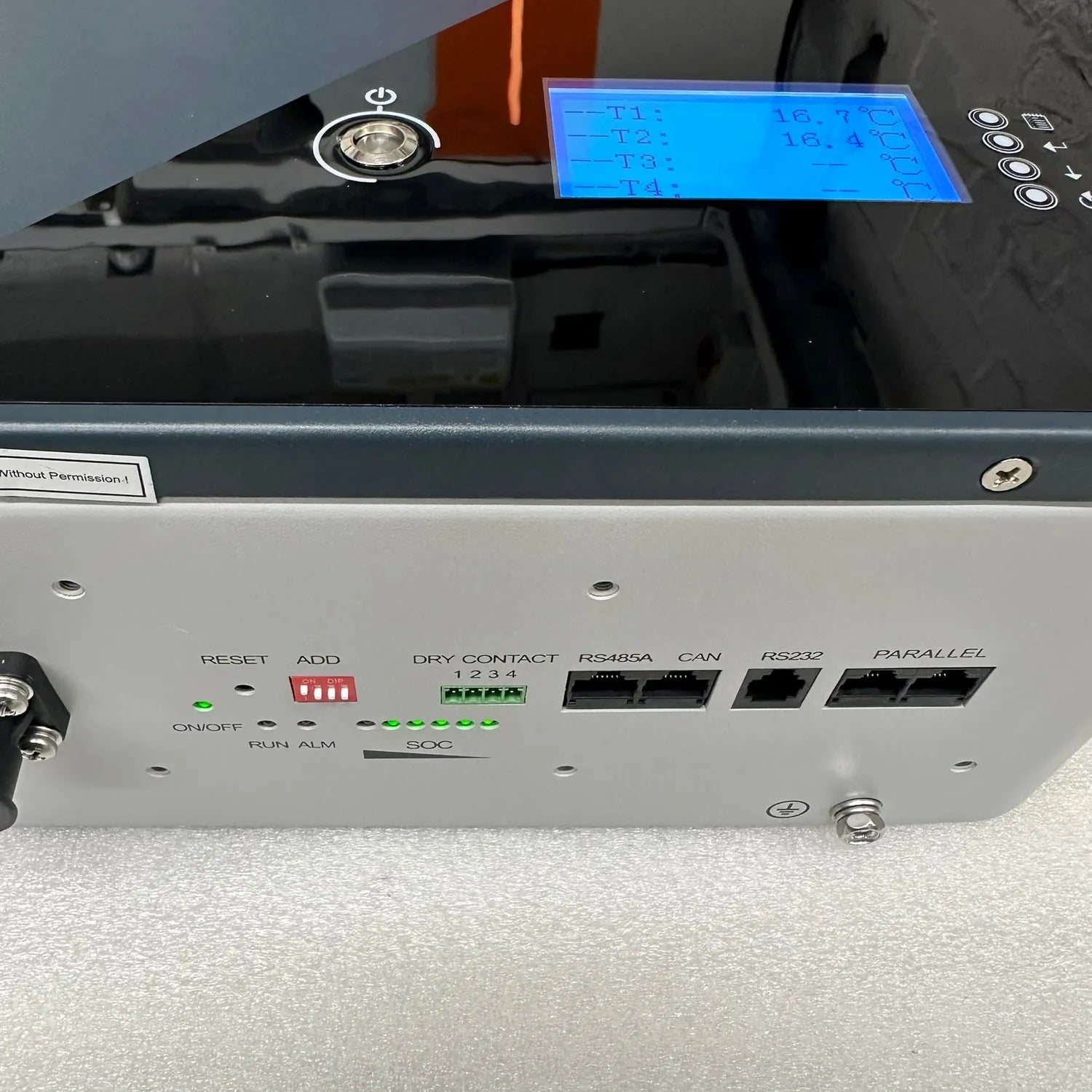 LiFePO4 battery unit showing front control panel with blue LCD display, reset button, dry contact terminals, RS485 and RS232 