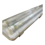 Linear LED tube fitting with clear polycarbonate cover and white housing, featuring two fluorescent tubes with brass connecto