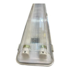 Clear polycarbonate LED tube fitting with ribbed dome and white base, showing two brass-colored lamp sockets.