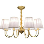 Brass chandelier with eight curved arms, twisted rope stem, and cream linen shades against white background.