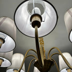 Aurelia Gold 8 Light Chandelier viewed from below, showing brass arms with white fabric shades and central stem against ceili