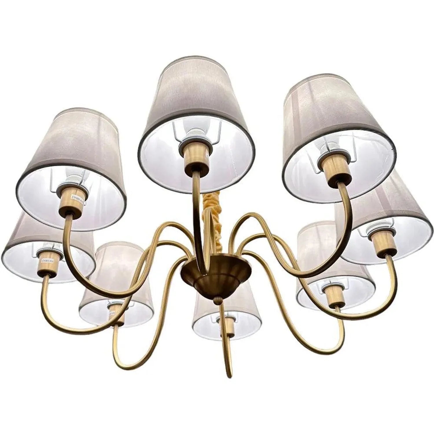 Eight-light chandelier with curved brass arms, white fabric drum shades, and central bronze canopy, shown against white backg