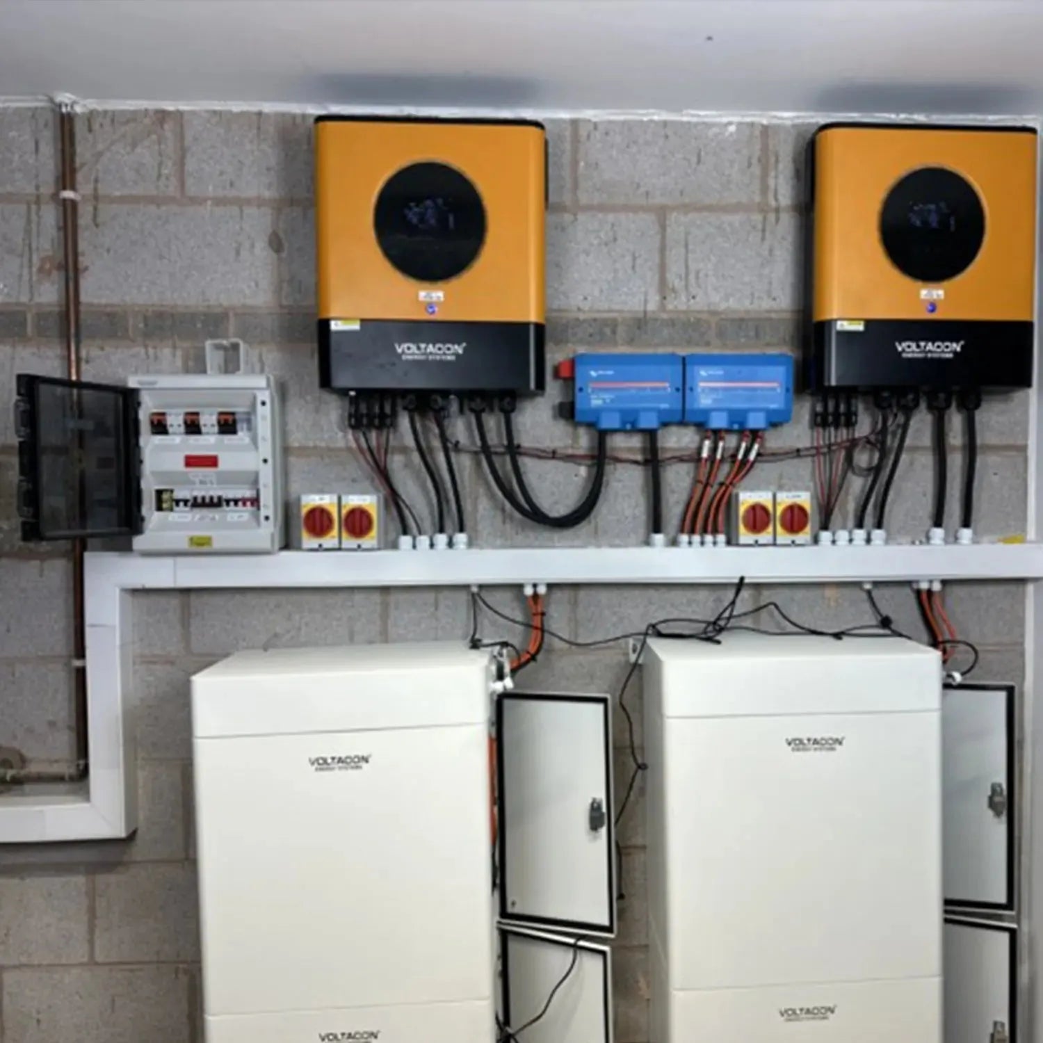Voltacon off-grid solar installation with two yellow inverters, blue battery management units, white lithium battery storage 