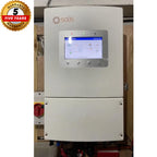 Solis 8kW hybrid solar inverter mounted on wall with touchscreen display showing system diagram, red isolation switch visible