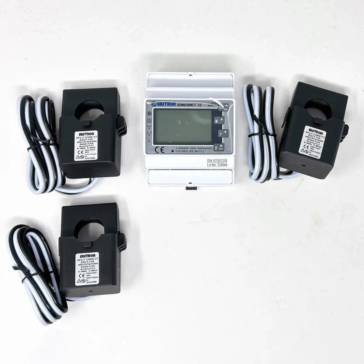 Eastron SDM630MCT energy meter with display and three black split-core CT clamps with attached cables, laid out on white back