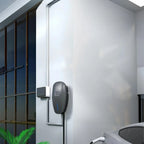Wall-mounted black 11kW EV charger with blue indicator light installed on white exterior wall next to gridded window, showing