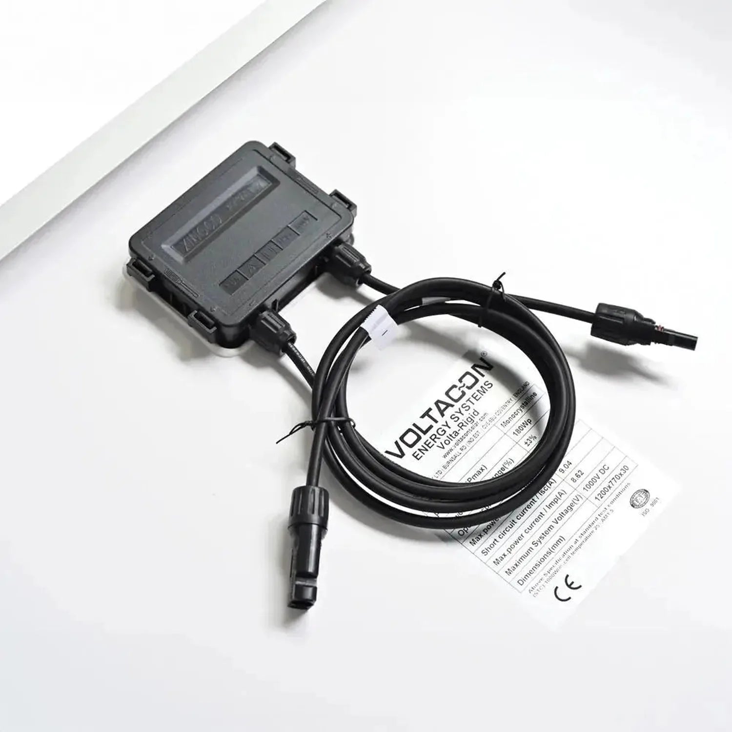 Voltacon solar panel energy system controller with coiled black cable and instruction manual on white background.
