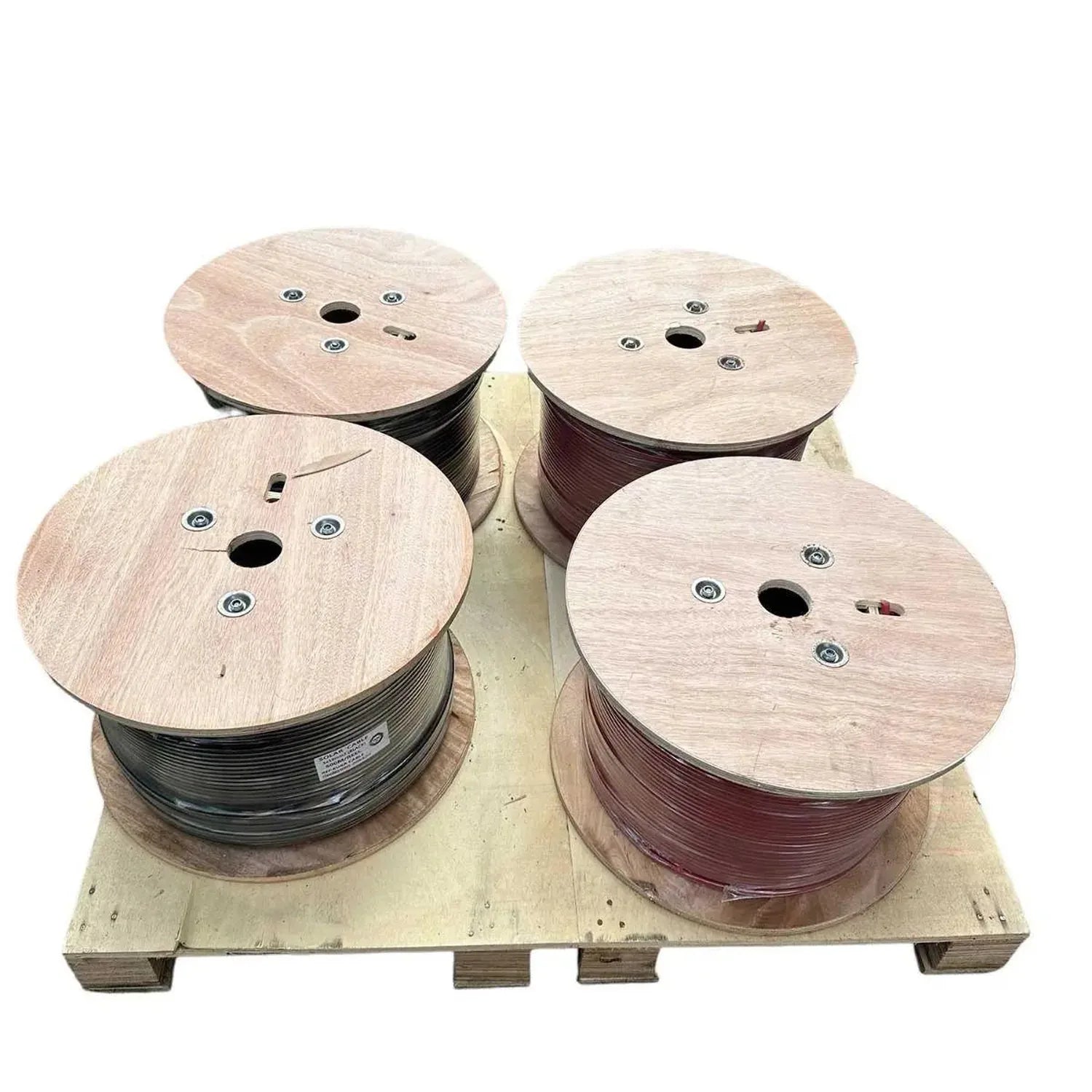 Four wooden cable drums on wooden pallet, two containing black wire and two containing red wire