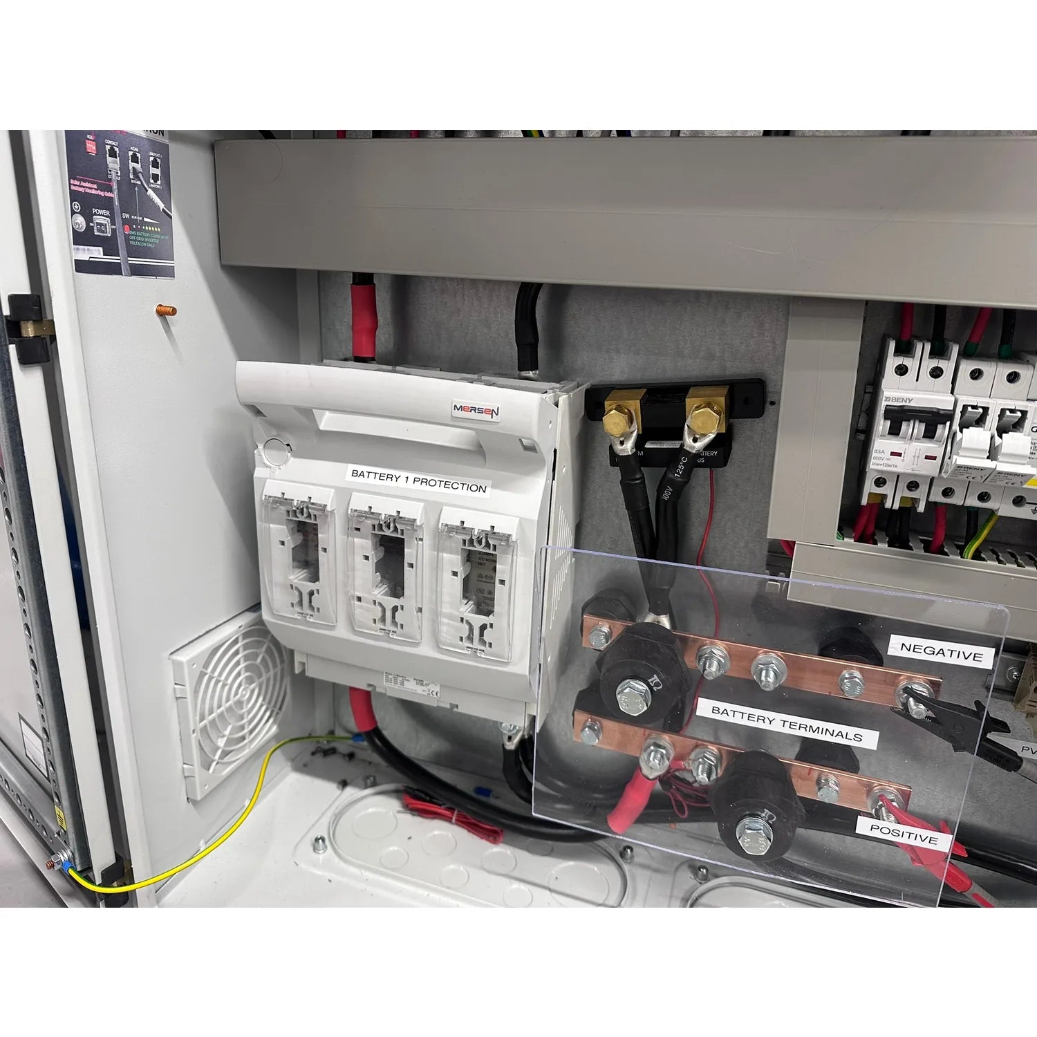 Interior installation view of off-grid solar control cabinet showing battery protection module, terminals, circuit breakers, 