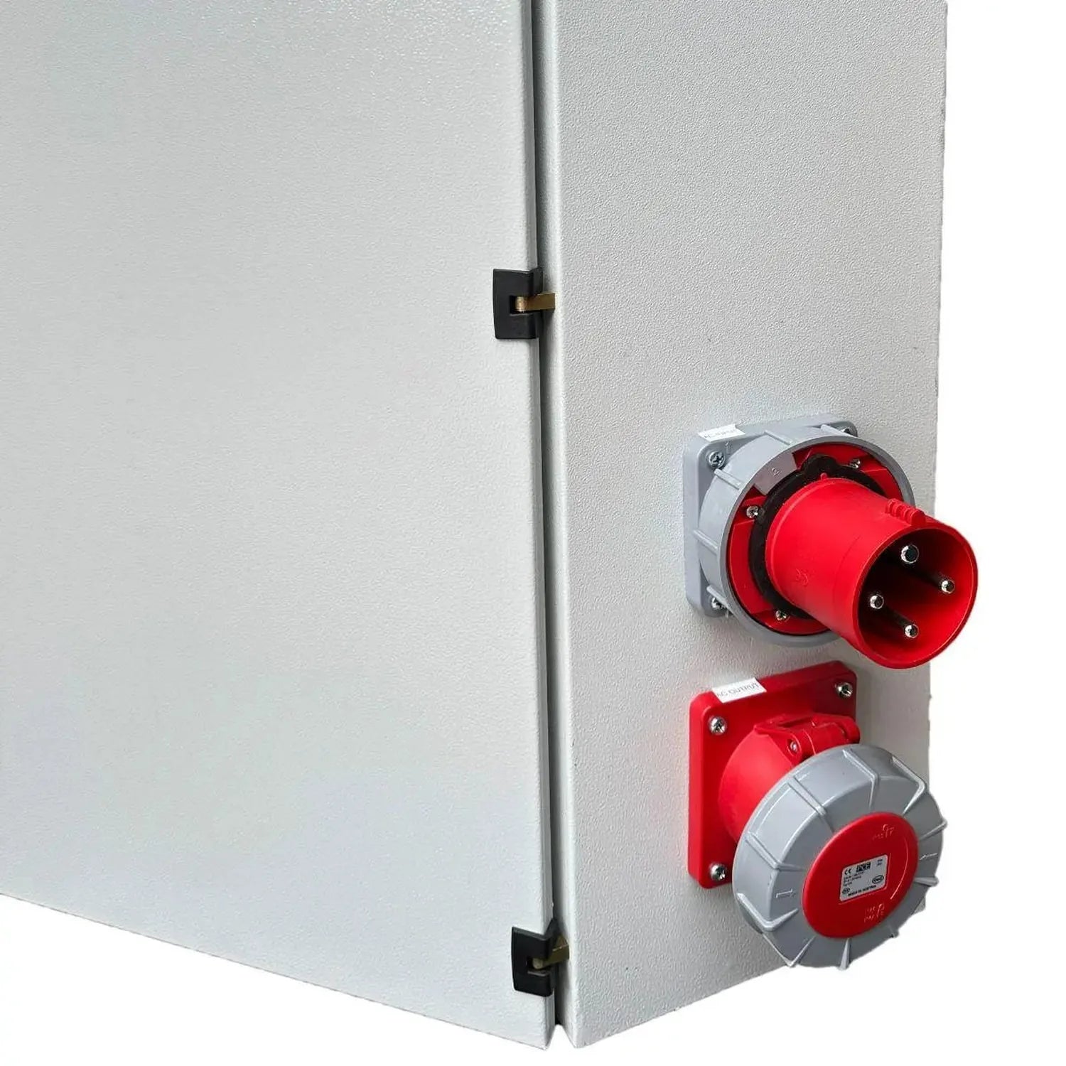 White metal cabinet with red industrial power connectors and outlets mounted on right side, installation shot.