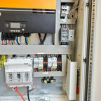Off-grid solar power cabinet interior showing inverter display, circuit breakers, battery protection module, and wiring insta