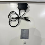 Black solar panel junction box with cables and Victron Energy specification label with barcodes on white surface.