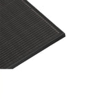 Close-up angled view of black monocrystalline solar panel showing grid pattern of cells and frame edge.