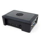 Black rectangular monitoring device with ventilation grill on top, USB ports and power connector on front side, Ethernet port