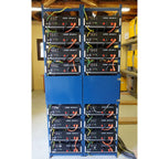 Two blue racks mounted with twelve Pylontech US5000 lithium ion batteries stacked vertically, connected with yellow and red c