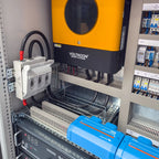Voltacon energy systems cabinet installation showing yellow inverter, battery storage units, white controller, and electrical