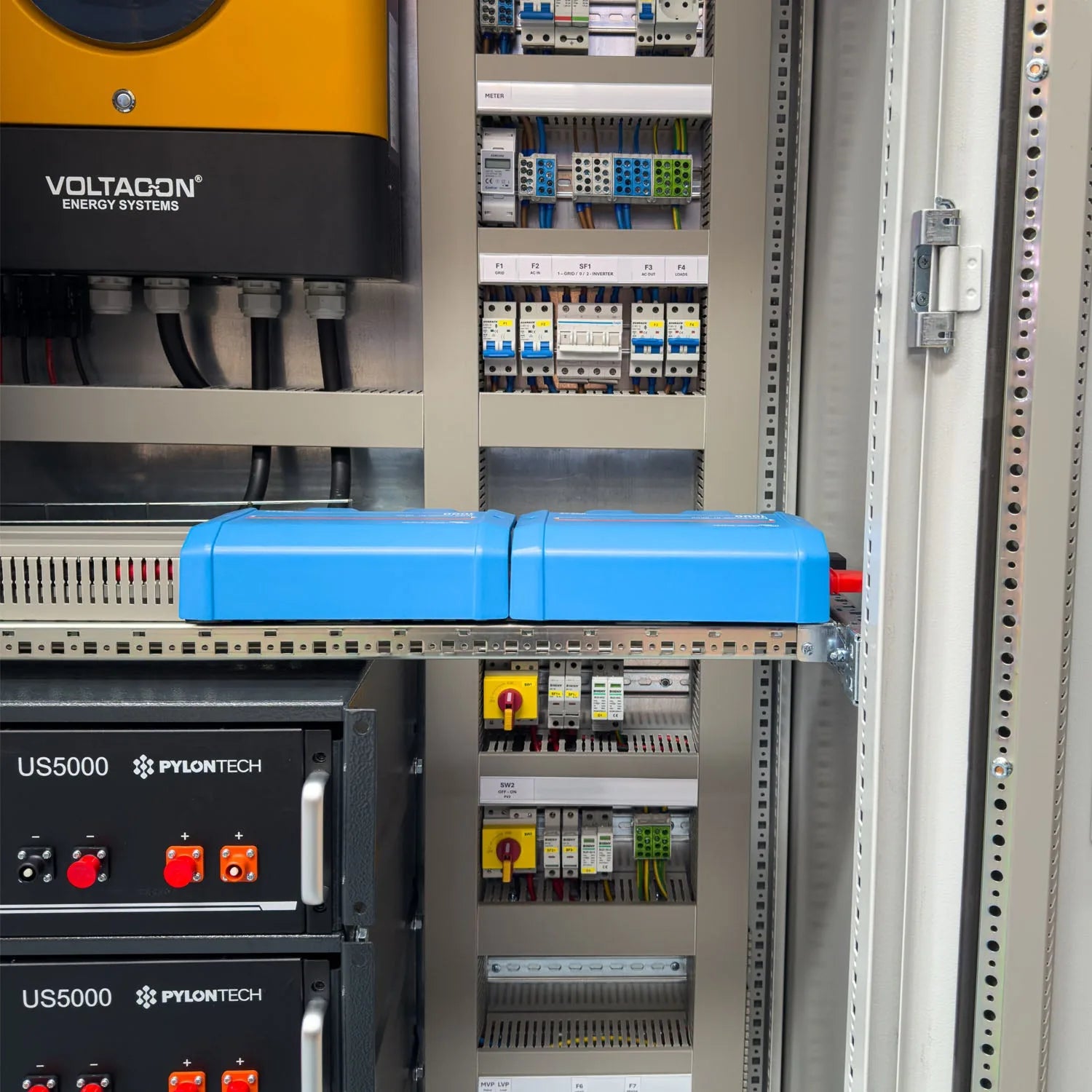 Voltagon Energy Systems off-grid power cabinet installation showing stacked Pylontech US5000 battery units, circuit breakers,