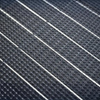 Close-up detail shot of flexible solar panel surface showing diagonal rows of monocrystalline cells with white frame separato