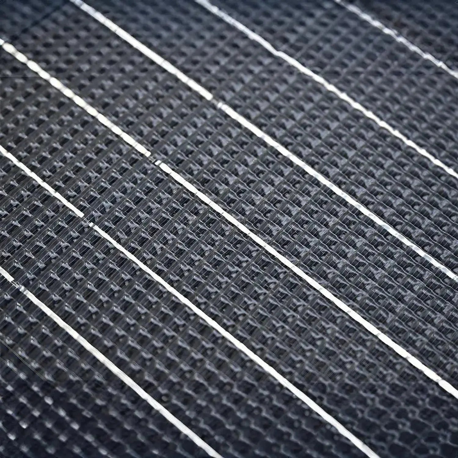 Close-up detail shot of flexible solar panel surface showing diagonal rows of monocrystalline cells with white frame separato