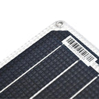 Close-up of flexible solar panel corner showing black monocrystalline cells with white frame and barcode label.