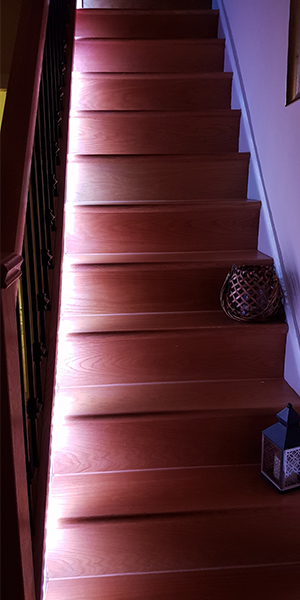 Wooden staircase illuminated by LED strips RGB Warm white